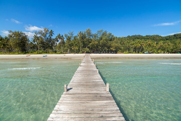 Wooden pier to a tropical island beach on Koh Kood island during day time, Thailand.