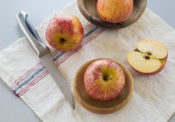 whole and sliced apples with leaves on white background
