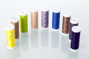 Sewing equipment and  threads on white background.