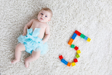 Adorable baby girl on white background wearing turquoise tutu skirt. © Irina Schmidt