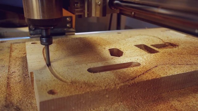 Manufacture of guitars. Milling a guitar deck on a machine with numeric control programs.