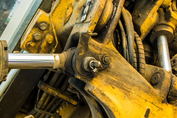 Dirty yellow excavator bulldozer hydraulic system pressure parts