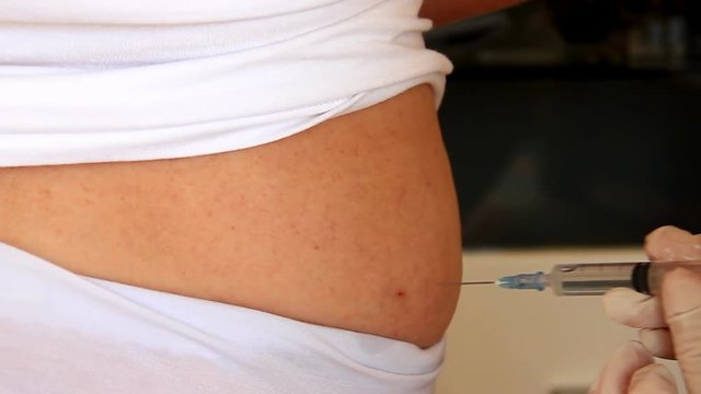 Doctor injects the injection with medicine into gluteus muscle of patient
