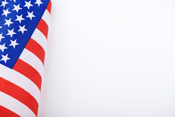 Studio shot of small bright flag of USA lying on white background. Copy space.