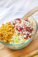 Chinese cabbage, sweet corn and surimi in a glass bowl