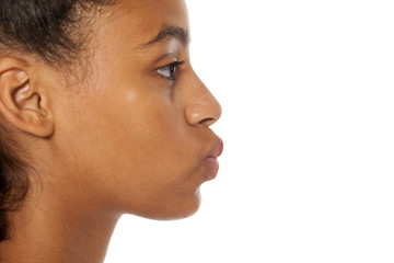 profile of beautiful dark skinned girl with pursed lips on white background