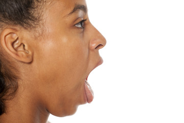 Fototapeta premium profil piękna ciemnoskóra dziewczyna z otwartymi ustami i językiem na białym tle