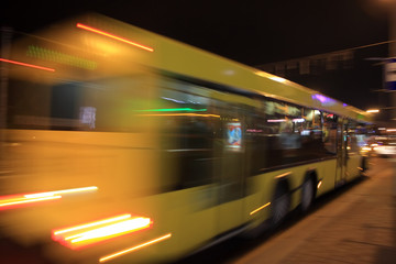 Fototapeta na wymiar The motion of a blurred bus in the street in the evening