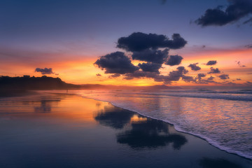 clouds reflections on beach at sunset