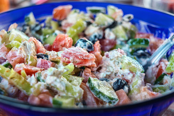 Greek salad on a blue plate, close, selective focus