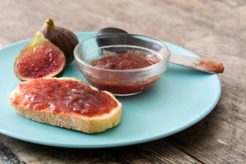 Sweet fig jam smeared on a toast on wooden table
