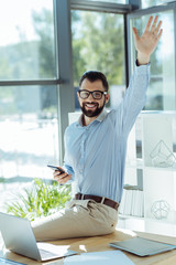 Joyful man greeting someone entering his office