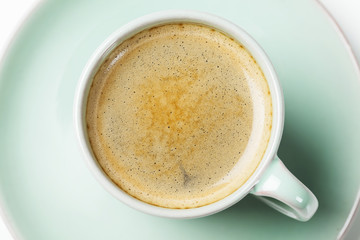 Turquoise cup of coffee with saucer, close up