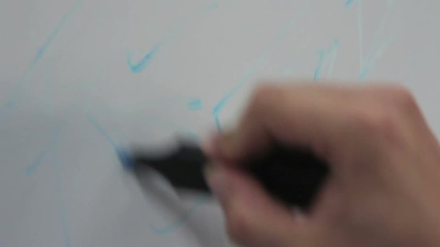 Compound of two frames: man draws a sketch on a flipchart with a blue marker close-up and macro