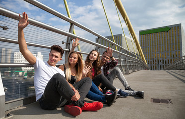 Group of friends sitting together outdoor on urban scenery