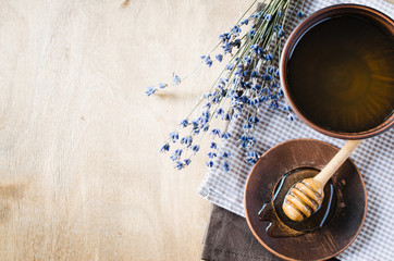 Organic honey and lavender flowers on wooden table.