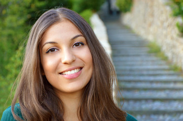 Woman smiling with perfect smile and white teeth outdoor and looking at camera. Copyspace,