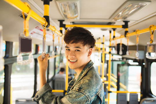 Asian Man Taking Public Transport, Standing Inside Bus.