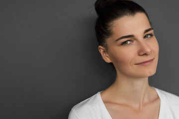 Horizontal close-up portrait of friendly happy brunette Caucasian woman wearing casual T-shirt...