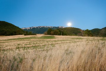 Nice view over the mountains and fields in the hills underneath an emerging moon