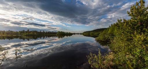 A dramatic sky reflecting in a calm lake in Lapland.