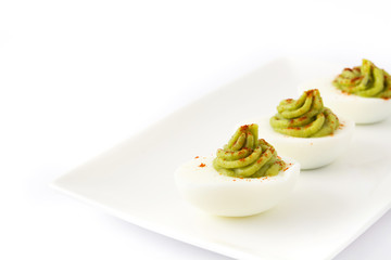 Stuffed eggs with guacamole isolated on white background

