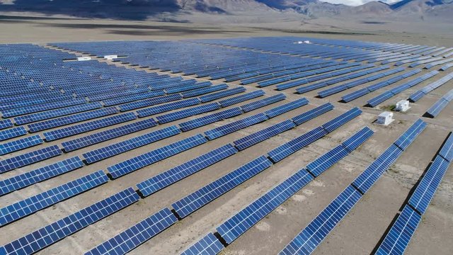 Aerial industrial view Photovoltaic solar units desert environment producing renewable energy, 4k slow motion aerial shot.