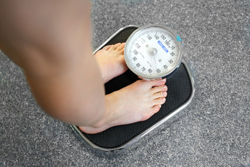 Fototapeta Prawidłowy ciężar ciała.
Kobieta waży się na wadze łazienkowej.
 obraz