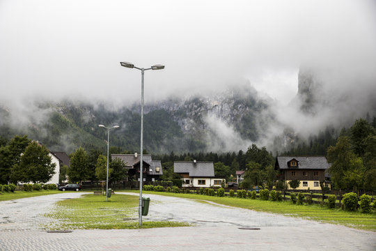 An almost empty parking lot in Hallstatt, Austria, covered in fog