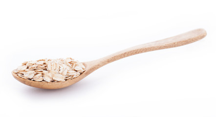 Oats in wooden spoon on white background
