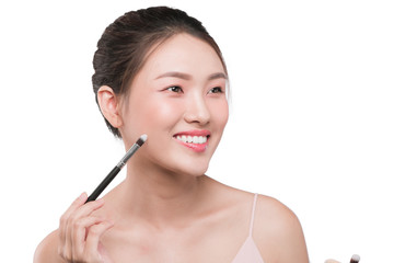 Portrait of attractive young asian woman holding make-up brushs over white