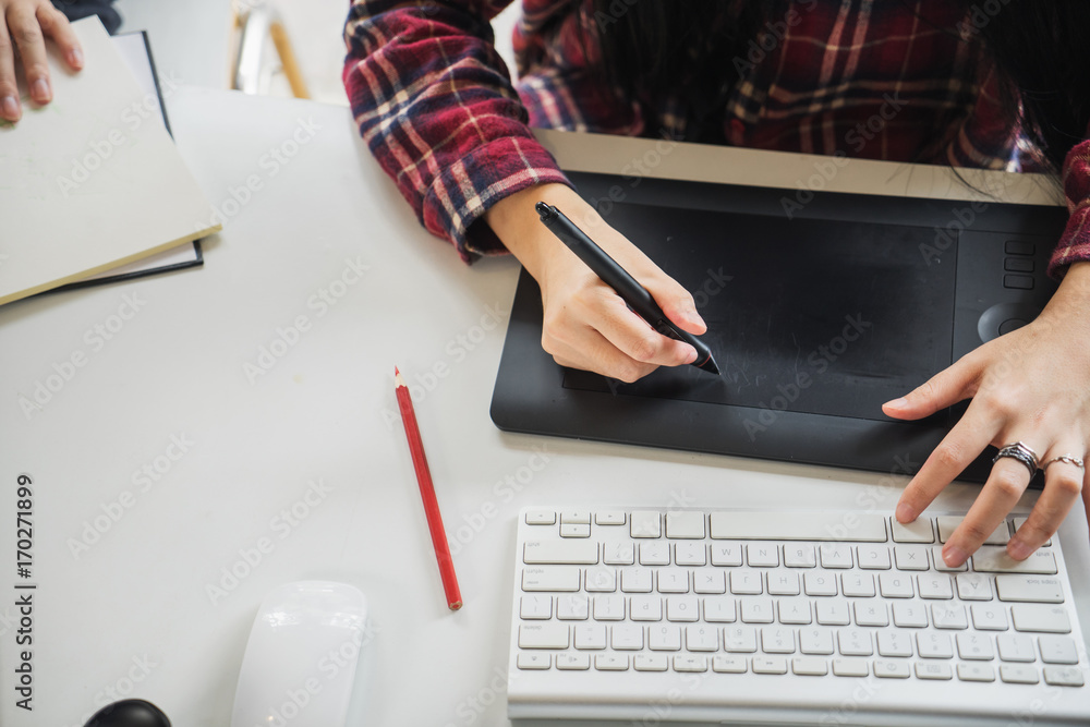 Poster graphic designer using digital tablet and computer in the office