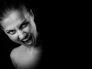angry nude girl screaming at camera on black background with copy space, monochrome