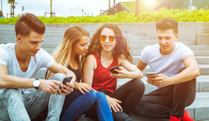 Group of friends sitting together using their phones