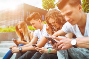 Group of friends sitting together using their phones