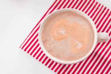 Top view of hot coffee with milk top view on a striped napkin on wood table background