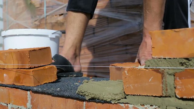 Work lays bricks on a construction site on open air