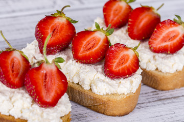 Sandwich of strawberry and cottage cheese on the wooden table, closeup