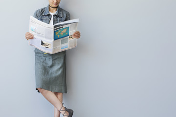 Young business woman reading newspaper