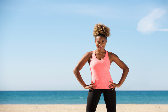 Healthy Black Young Woman Standing With Hands On Hips At The Beach