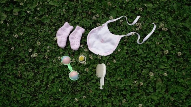 Baby booties, bib rattle on grass