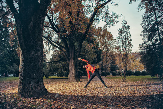 Male runner stretching and warming up in park