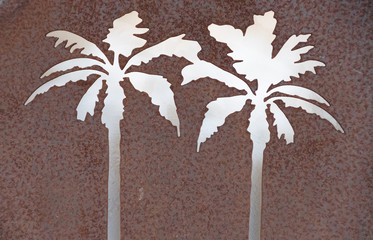 Palm tree stencil shapes cut out of rusty metal sheet