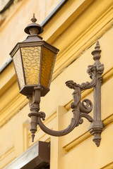 Fototapeta na wymiar Street lamp on the wall of an old house