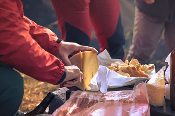 Photo sur Plexiglas Pique-nique collation dans la montagne, la main de l& 39 homme coupe la nourriture