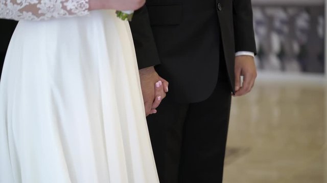 Bride and groom holding hands at wedding ceremony