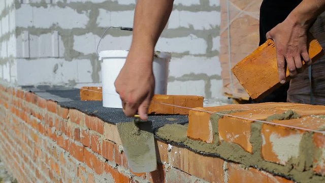 Work lays bricks on a construction site on open air