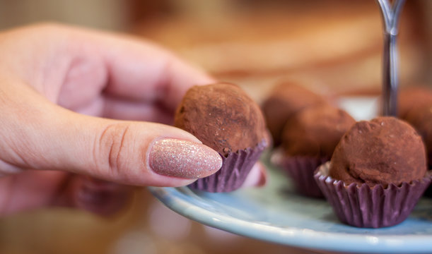 M&atilde;os femininas pegando Trufas de chocolate em uma festa de anivers&aacute;rio