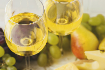 Cheese plate served with wine, fresh grapes and pears