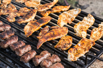 Flat lay above chicken white breast meat on the barbecue grill with kebabs